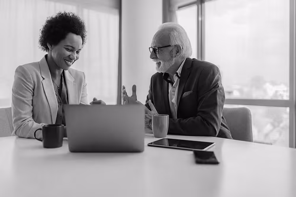 Senior,Businessman,Discussing,With,Female,Executive.,Smiling,Male,And,Female